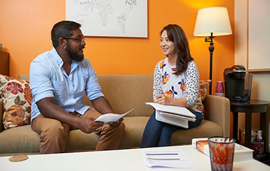 An advisor sits on a couch with an Ohio University student