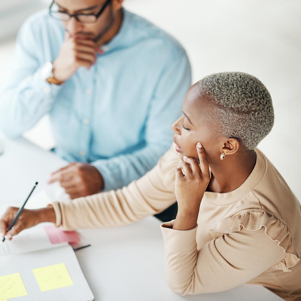 Professional person writing something on paper while someone else watches