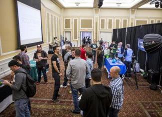 A group of people try out various video games on the BOGS exhibit floor